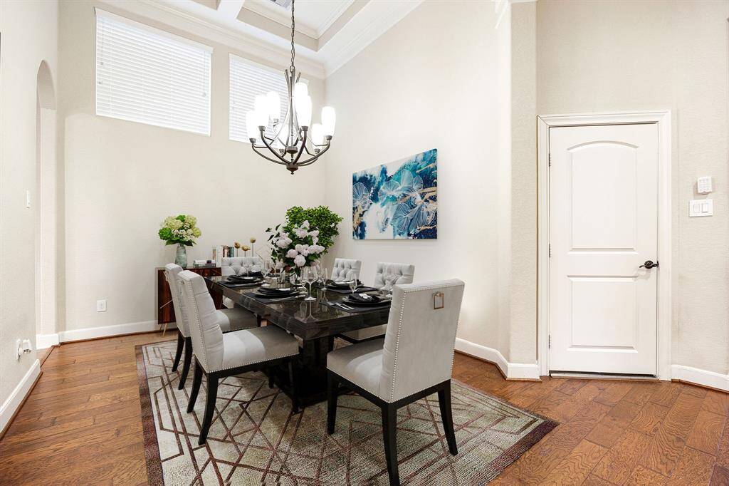 You and your guests will certainly dine in style in this amazing formal dining room! Featuring a gorgeous modern chandelier, windows with blinds, neutral paint, high ceilings, crown molding and wood flooring. Perfect space to entertain family and friends. *virtually staged*