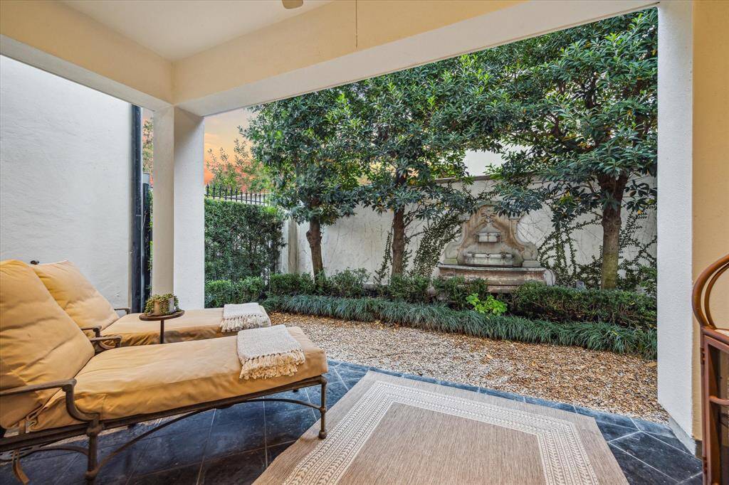 Covered first floor patio looking onto mature Japanese blueberry trees and fountain.