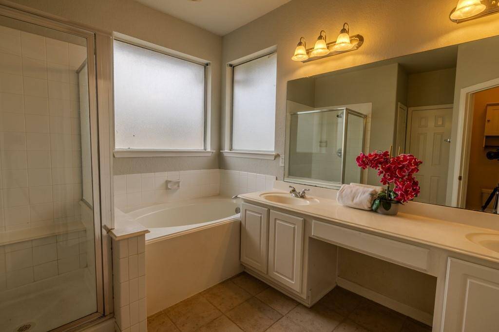 Well appointed primary bath with water closet, built in vanity, double sinks and separate tub and shower