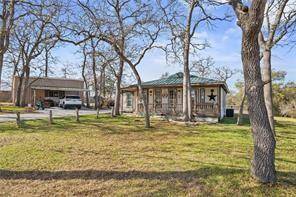 Ranch-style house featuring a carport, covered porch, and a front yard