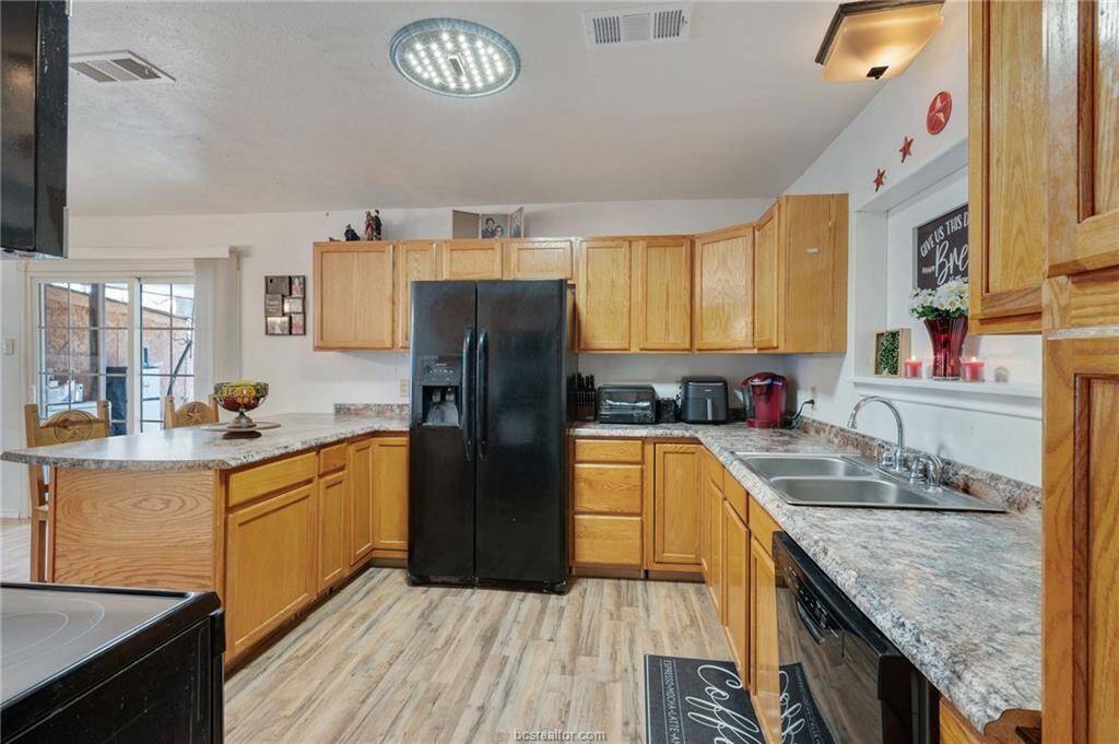 Kitchen featuring black appliances and lots of cabinets
