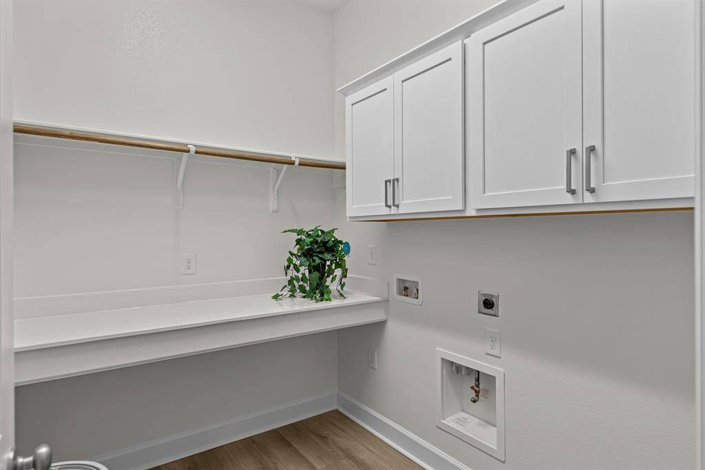 Large utility room with folding table and upper cabinets for storage!  Plumbed for gas or electric dryer