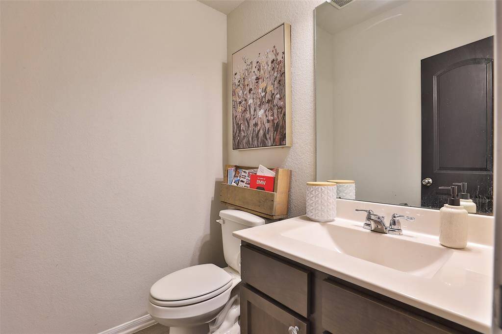 A half bath featuring beautifully finished painted doors that create a striking natural contrast.
