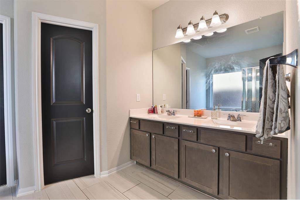 The primary bath features a double vanity, separate tub and shower, and a spacious walk-in closet for added convenience.