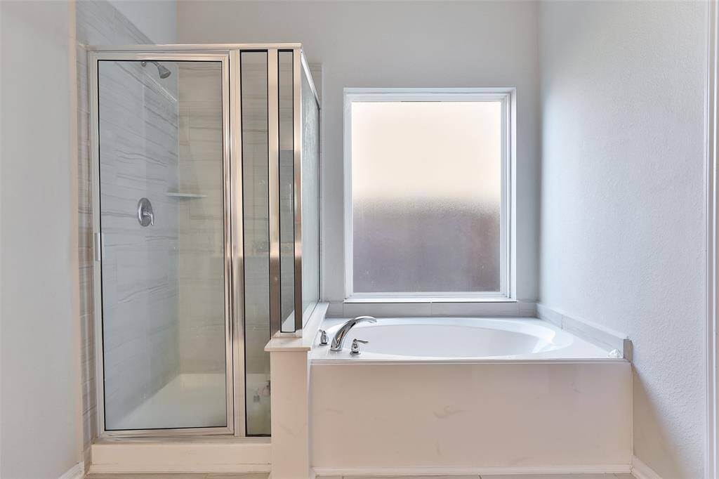 The soaking tub and separate shower offer additional space and a relaxing retreat.