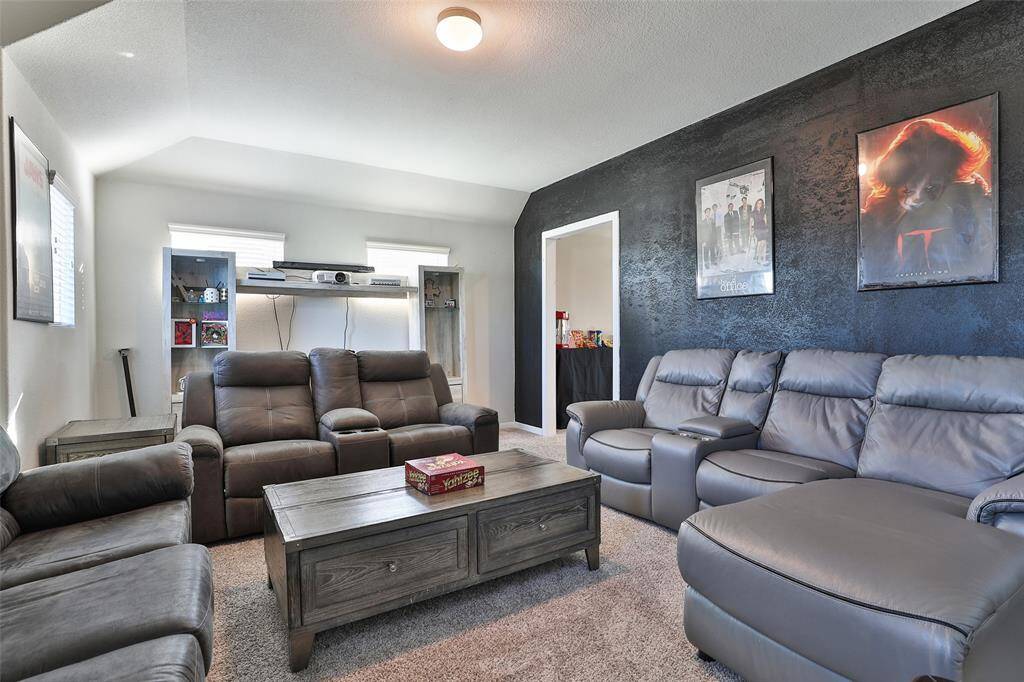 The black accent wall adds a truly unique touch, blending seamlessly in this versatile hybrid room.