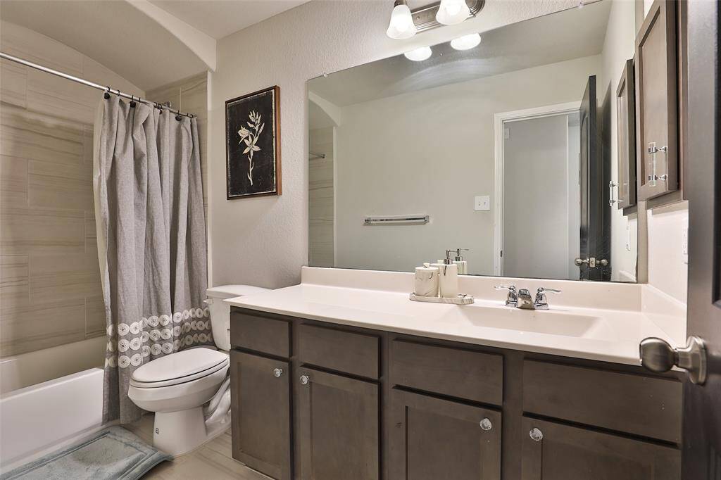An upstairs full bathroom featuring ample counter space for added convenience.