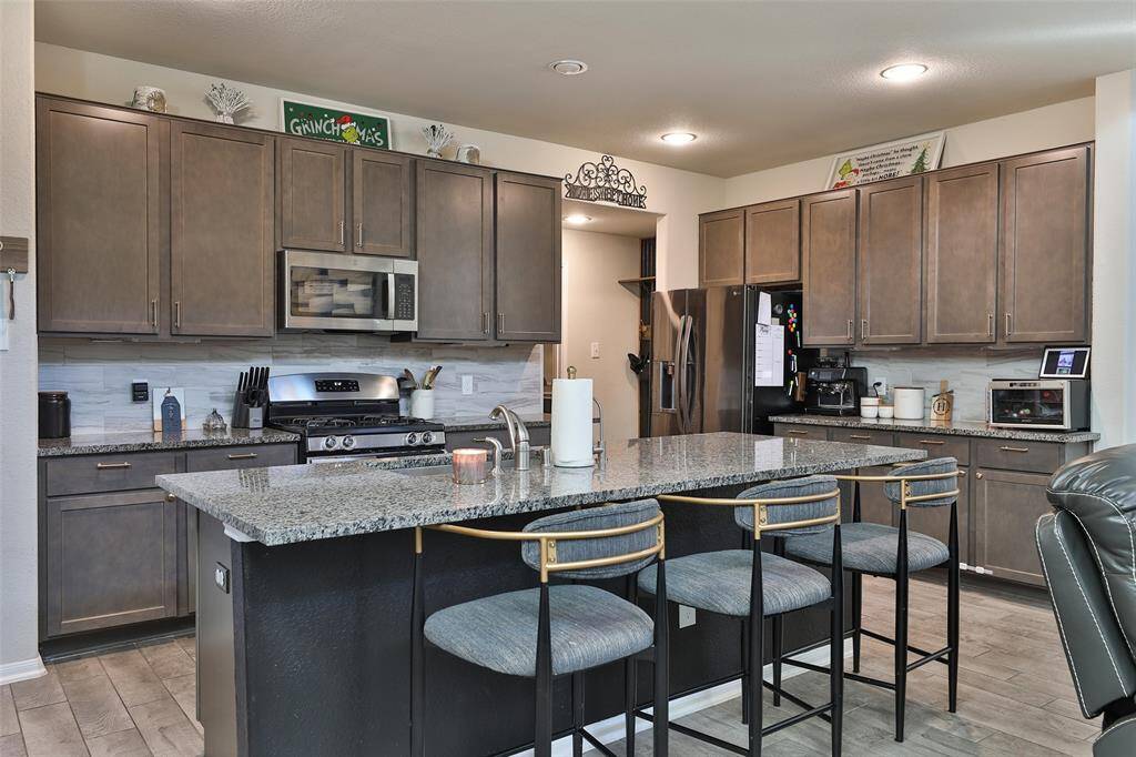 The kitchen boasts a beautiful open-concept design with ample cabinet space and a spacious island that doubles as a convenient breakfast bar.