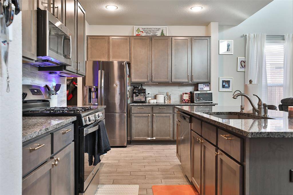 The farmhouse sink and gas oven enhance the home's theme of convenience and functionality.