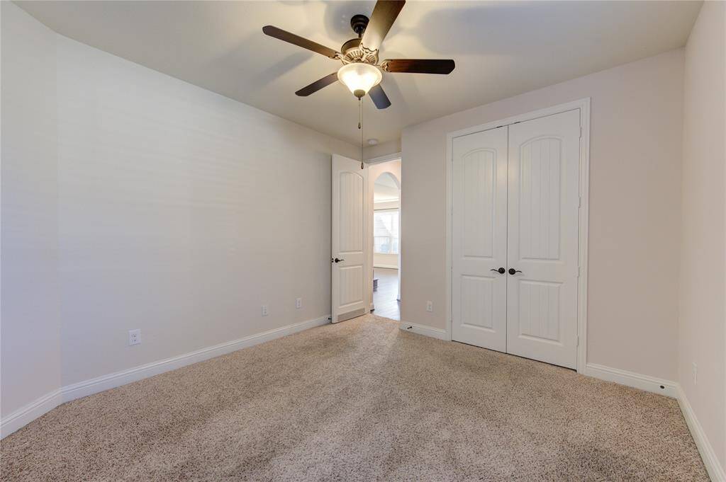Secondary bedroom located in the main floor, It includes double doors closet and offers a bright, open view through an adjacent doorway.