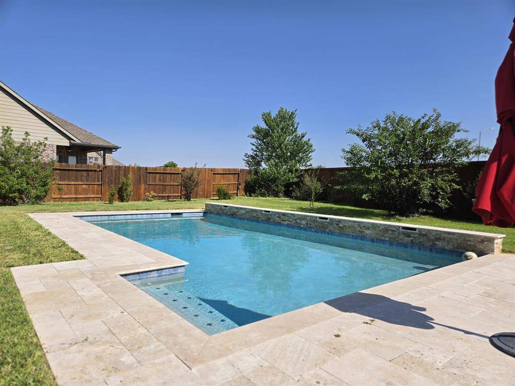 The sunbathing area, lush greenery, and pool harmoniously come together to create an unparalleled enjoyment experience right in your own backyard.