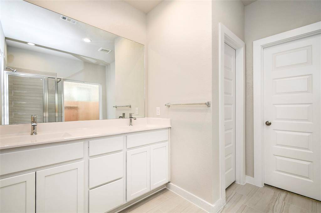 Escape to a spa-like oasis in this primary bathroom. Enjoy a walk-in showerwith tile surround, a separate garden tub with custom detailing, and an elegantvanity featuring light countertops, modern hardware, and beautiful recessed lights.Experience luxury and relaxation in every detail. Sample photo of completed home with similar floor plan. Actual colors and selections may vary.