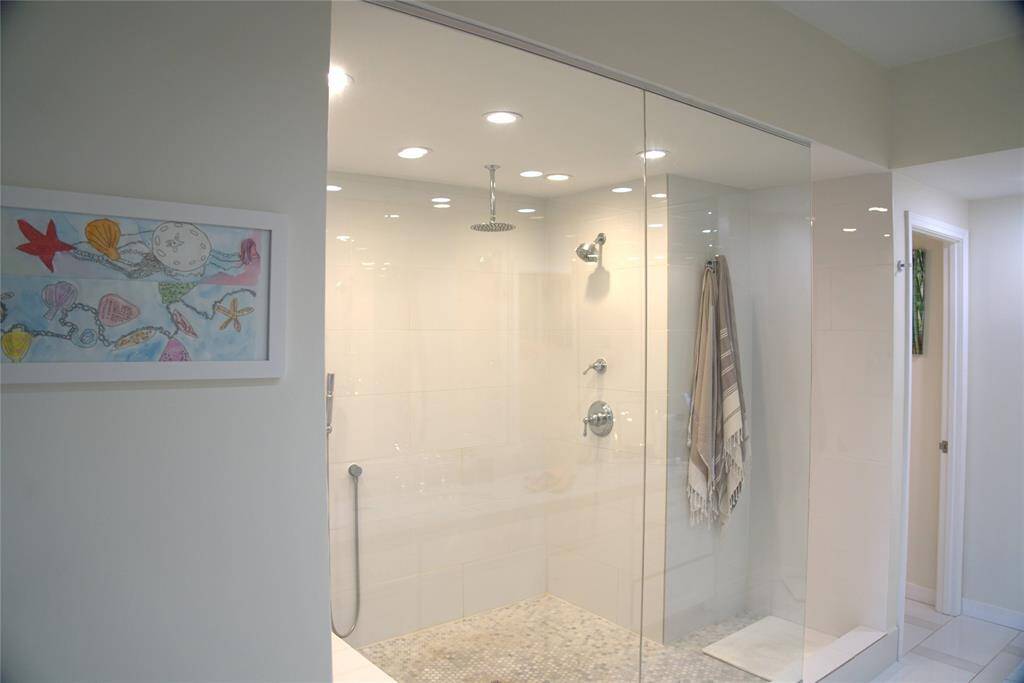 The master bathroom features a modern and spacious walk-in shower with dual and hand held shower heads, a built-in bench for your convenience, dual sinks, and an electric outlet for a bidet.