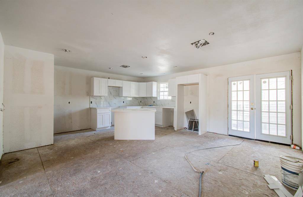 The kitchen features white cabinets and quartz countertops, ready for your finishing touches.