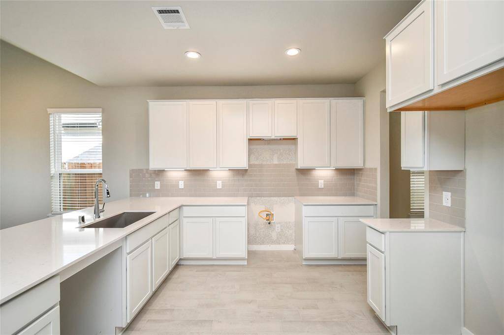 Welcome to a dream kitchen that exceeds expectations! This generously spacious layoutboasts high ceilings, soft-close cabinets, granite countertops, stainless steel appliances, a sleek tile backsplash, and recessed lighting. An extended counter area adds an extra layer of functionality. The open concept seamlessly connects this culinary haven to the expansive family room, creating the perfect hub for gatherings. Sample photo of completed home with similar floor plan. Actual colors and selections may vary.