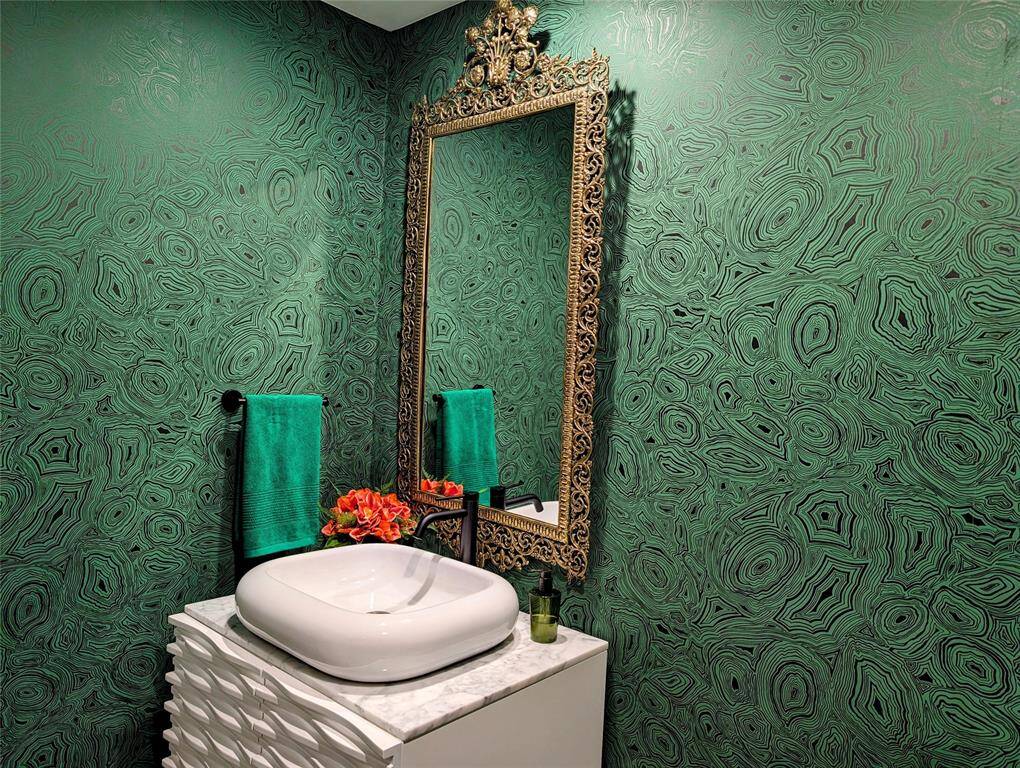 The powder room features wallpaper design by Piero Fornasetti and an electric outlet for a bidet.