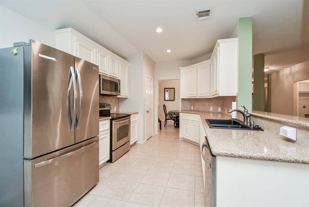 Modern kitchen with a breakfast area view, complete with a stainless steel refrigerator.