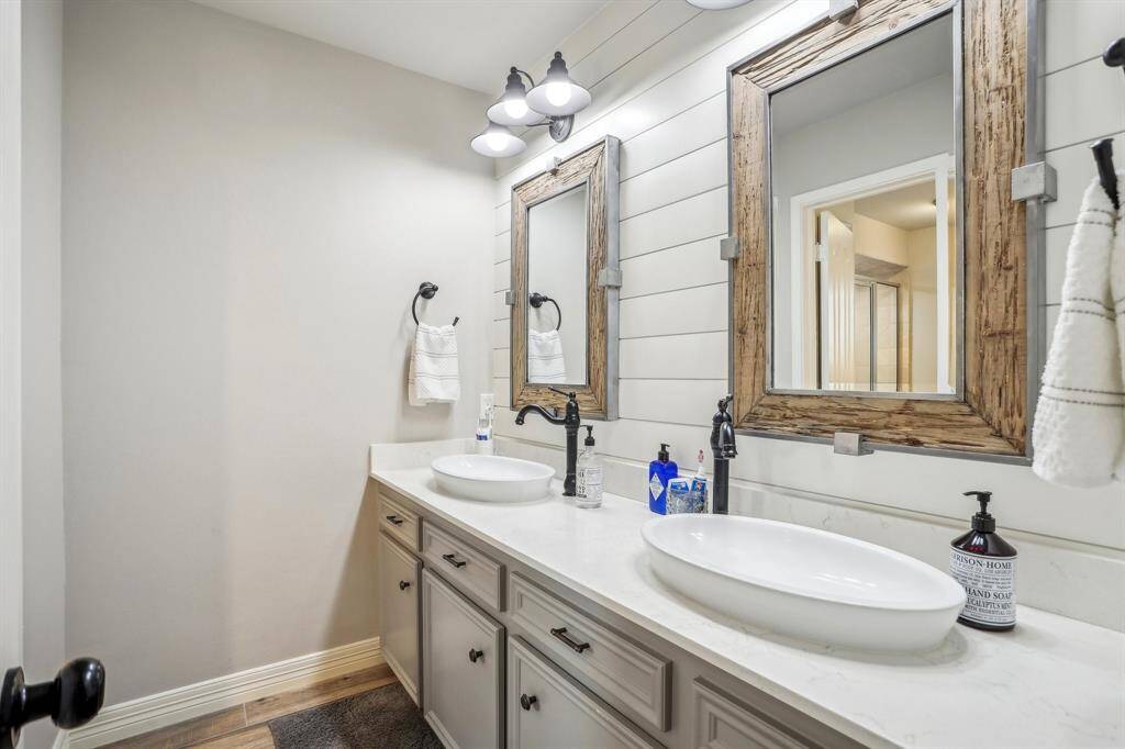 Elegant double vanity in the primary bath with stylish vessel sinks and rustic framed mirrors.