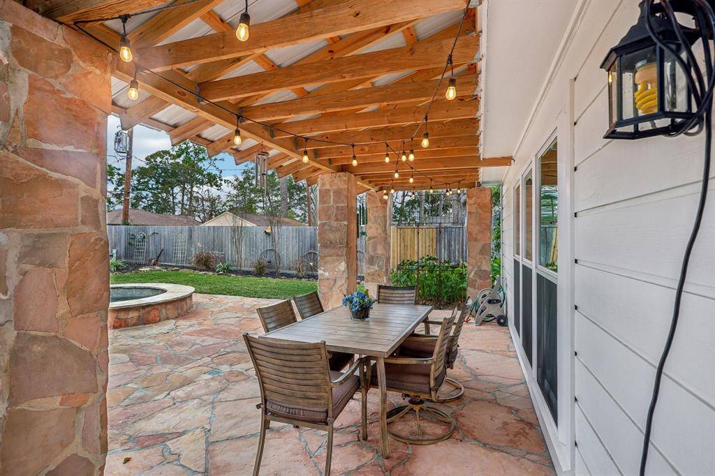 Charming covered patio overlooking a secluded pool.