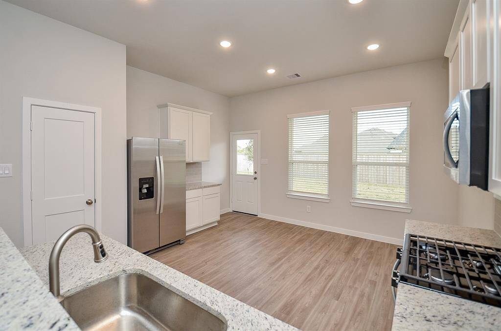 This is a truly workable kitchen, with great natural light, tons of vanilla colored cabinetry/storage, shining stainless steel appliances, gorgeous creamy quartz counter tops, and tremendous floor space for effortless tasking.