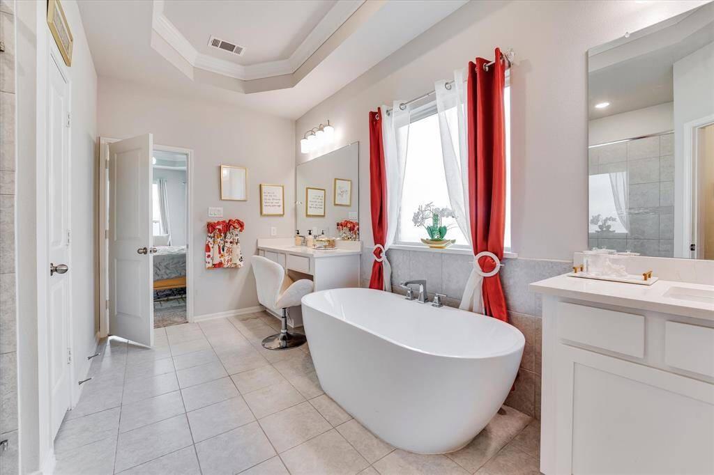 Primary suite downstairs for extra privacy, with tray ceiling and bay windows