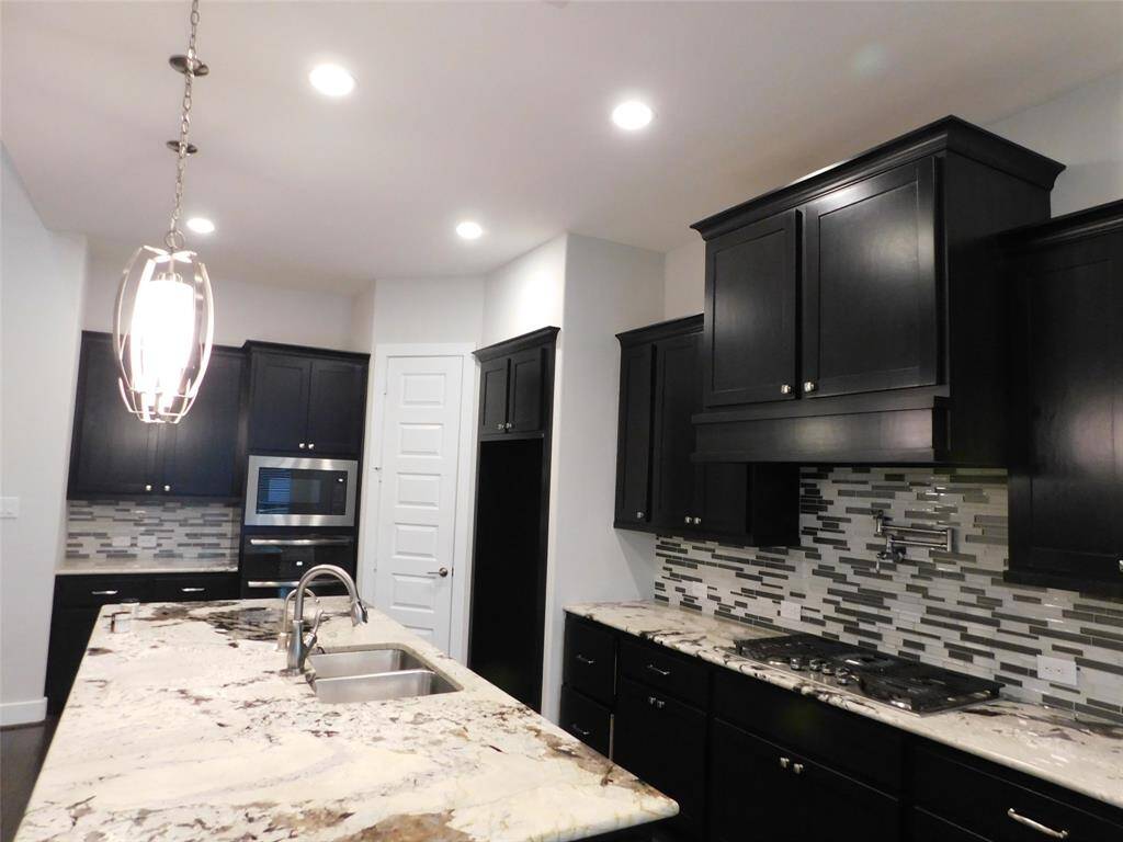 Elegant kitchen with modern cabinetry, sleek countertops, and high-end appliances, perfect for culinary enthusiasts.