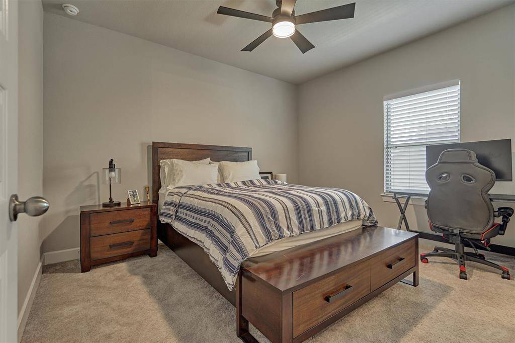 One Of Two Secondary Suites Upstairs; The Room Features A Ceiling Fan And Private En Suite Full Bath.