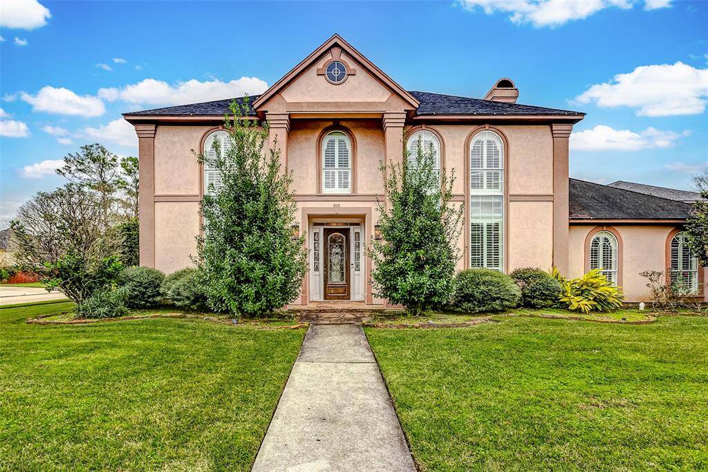 A warm welcome awaits as you approach the elegant double-door entryway. This meticulously maintained façade showcases timeless design elements, featuring arched windows and detailed columns that exude sophistication.