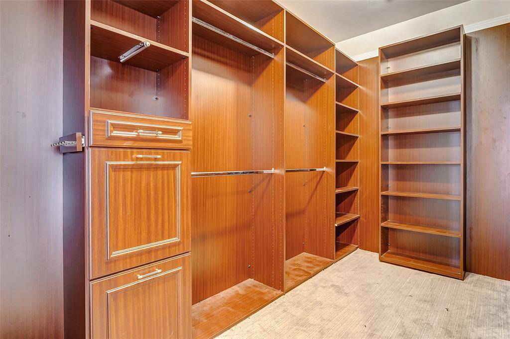 The walk-in closet offers custom-built shelving, drawers, and hanging space to keep your wardrobe organized in style.