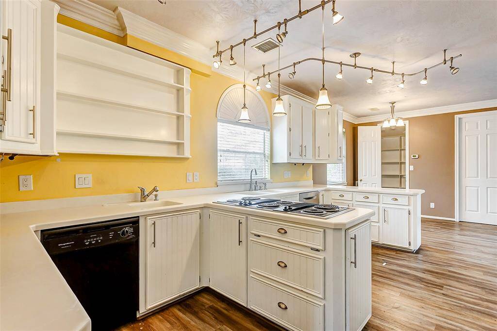 Featuring built-in appliances, open shelving, and a sunny dining nook, this kitchen is a blend of practicality and charm.