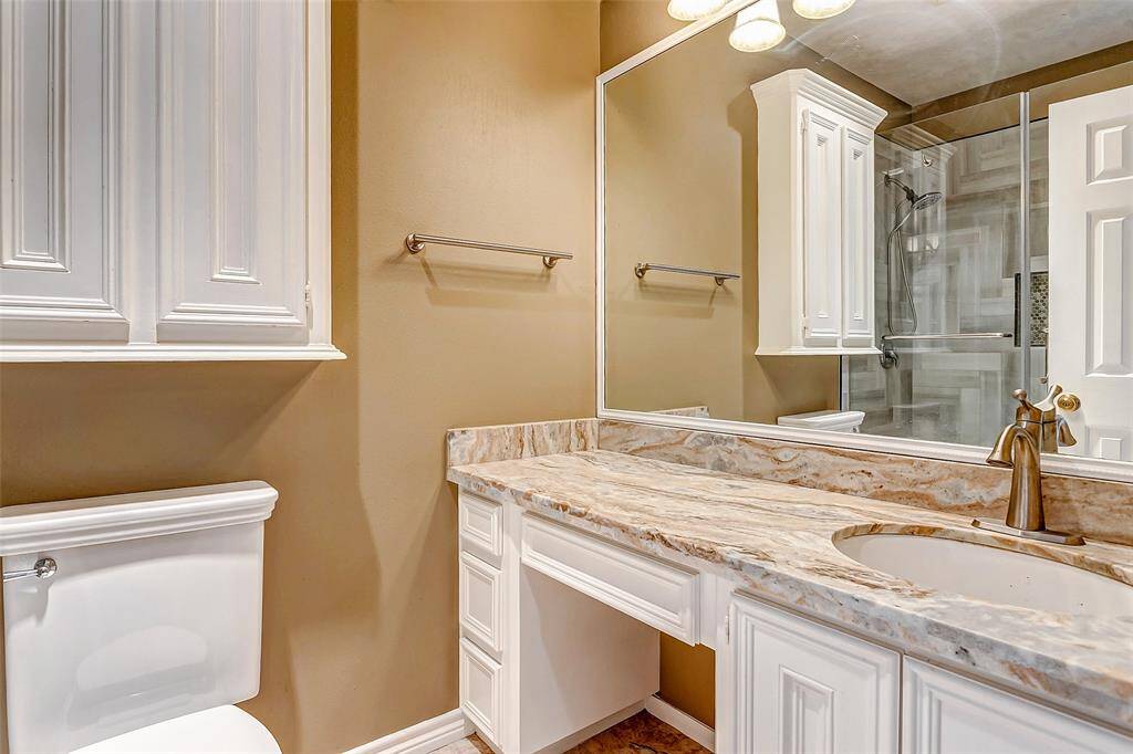 A well-appointed bathroom with marble-style countertops, ample cabinetry, and a spacious vanity for your morning routine.