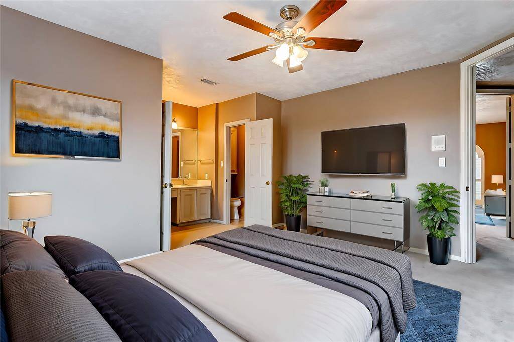 A tranquil secondary bedroom with classic charm, offering flexibility for use as a guest room, office, or playroom. Neutral carpeting and a soft palette provide a serene and adaptable environment.