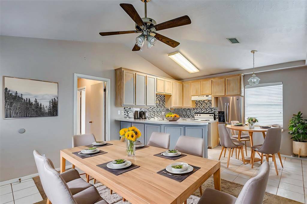 The full kitchen in the detached garage apartment offers convenience for guests or additional residents. Featuring modern backsplash tiles and ample natural light, it’s a functional yet inviting space.