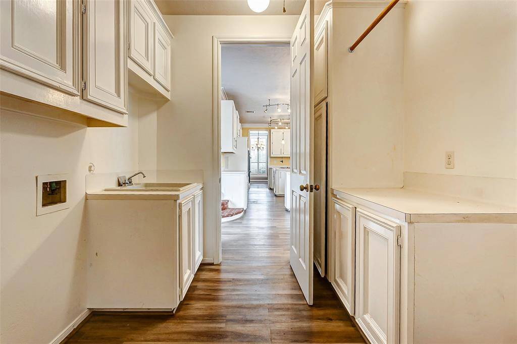 This well-organized utility space includes a convenient sink, plenty of cabinetry for storage, and easy access to the rest of the home.