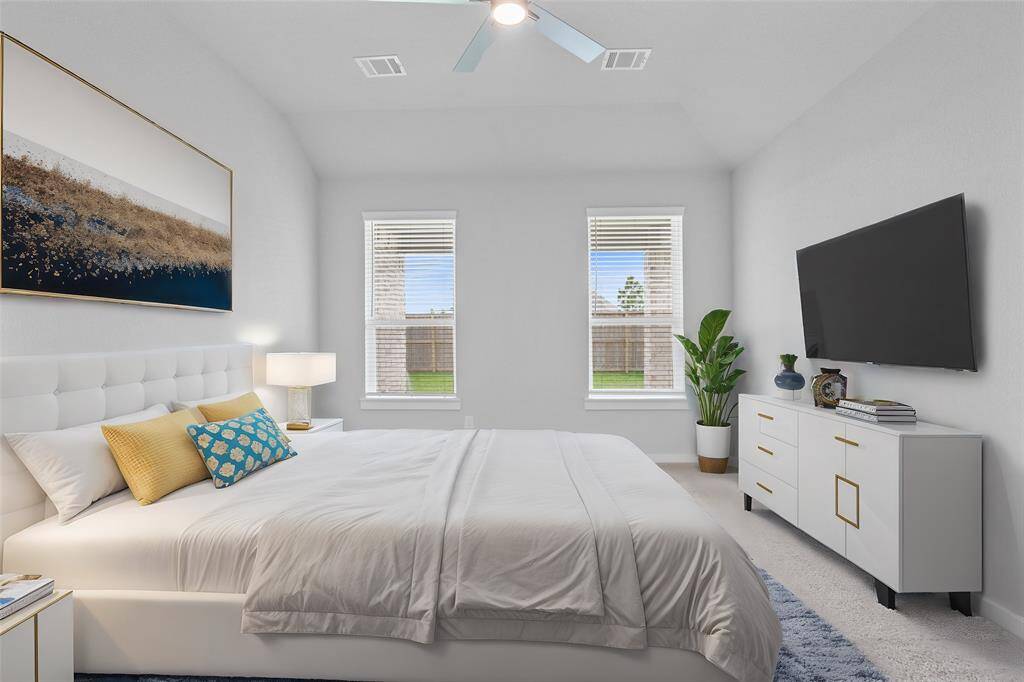 Come and unwind after a long day in this magnificent primary suite! This spacious room features plush carpet, warm paint, ceiling fan, high ceilings, and large windows with privacy blinds!