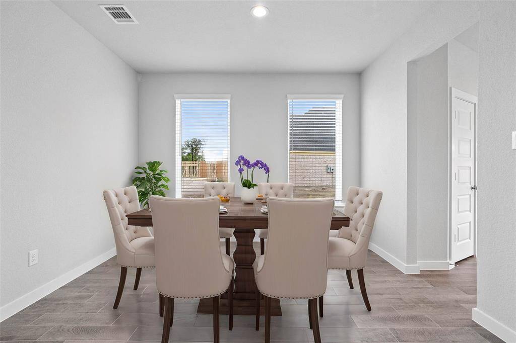 You and your guests will certainly dine in style in this amazing formal dining room! Featuring large windows with blinds, neutral paint, high ceilings, recessed lighting, and tile flooring! Perfect space to entertain family and friends!