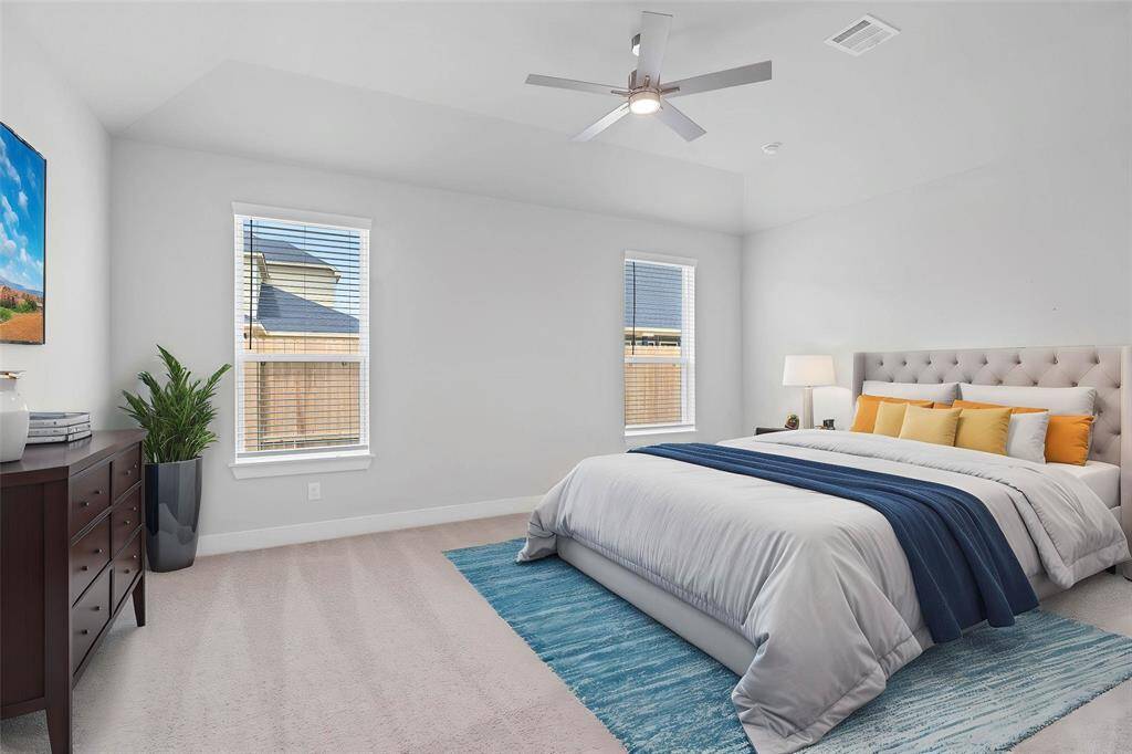 Come and unwind after a long day in this magnificent primary suite! This spacious room features plush carpet, warm paint, high ceilings, ceiling fan and large windows with privacy blinds.