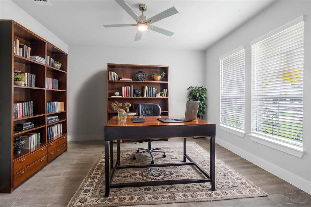 Quietly nestled in front of the home is the handsome home office! Featuring wood look tile flooring, ceiling fan, large windows with blinds and custom paint!