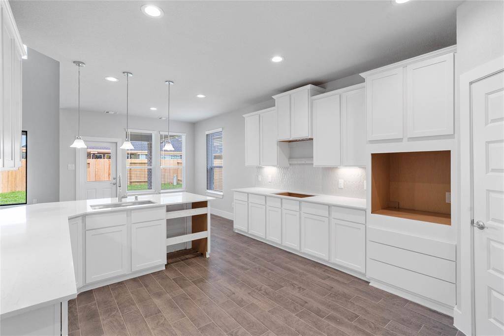 This kitchen is by far any chef’s dream! This spacious kitchen features high ceilings, stained wood cabinets, quartz countertops, SS appliances, modern tile backsplash, recessed and pendant lighting, extended counter space with sink and space for breakfast bar, and a walk-in pantry all overlooking your huge family room.