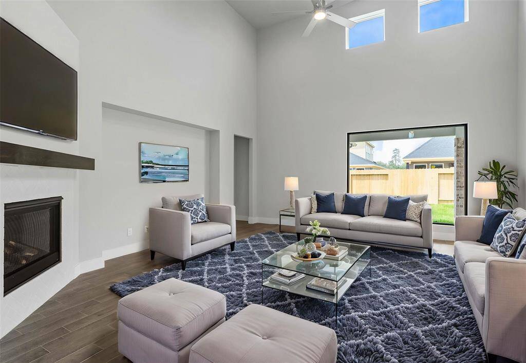 Gather the family and guests together in your lovely family room! Featuring a fireplace with wood mantel, large picture window, soaring high ceilings, recessed lighting, ceiling fan, custom paint, and gorgeous wood look tile floors.