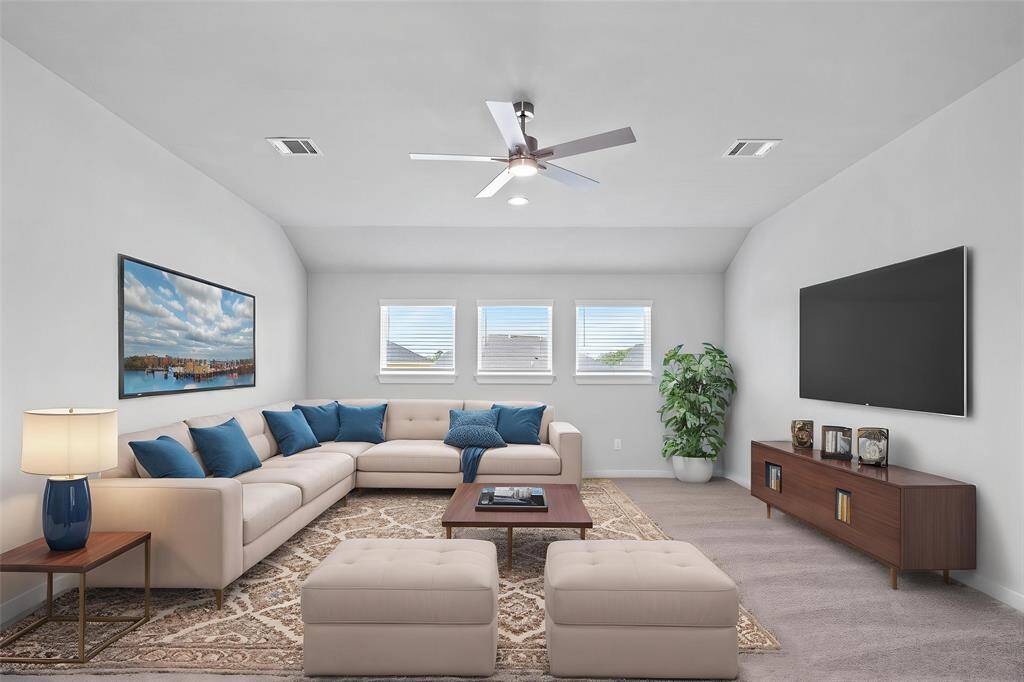 Come upstairs and enjoy a day of leisure in this fabulous game room! This is the perfect hangout spot or adult game room, this space features plush carpet, high vaulted ceiling, ceiling fan, custom paint and windows with blinds.