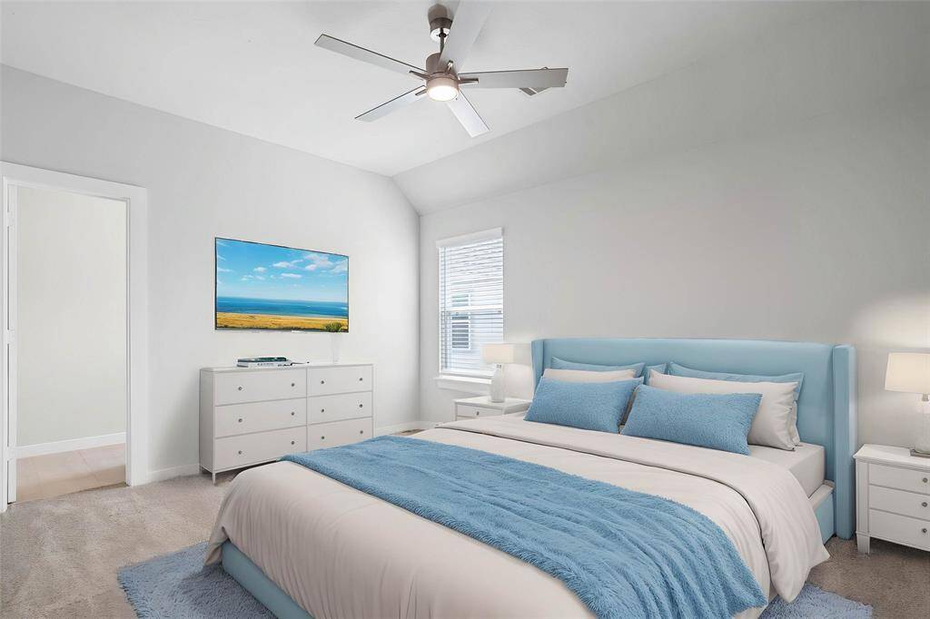 Secondary bedroom features plush carpet, custom paint, ceiling fan with lighting, large window with blinds, closet space, and its own private access to a secondary bathroom.