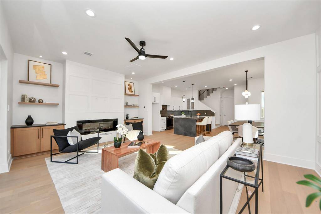 The fireplace accent is complemented by two cabinets, each featuring the same 3CM leather countertops as the waterfall island. Above, two shelves are illuminated by a 2-inch light, providing the perfect space to personalize the area.
