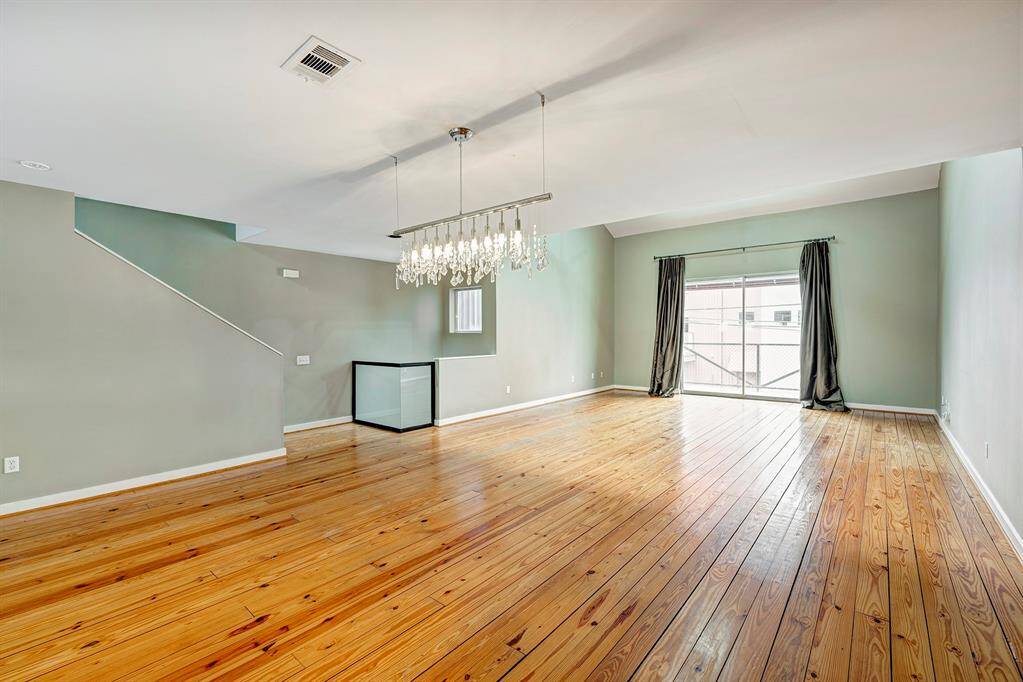 Second floor area has a beautiful living and dining area , gleaming wood floors ,contemporay chandelier for the dining area, high ceilings and a balcony . To the right of the room are stairs leading up to the Primary suite.