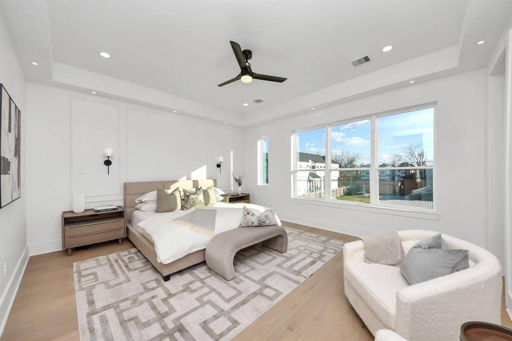 The Primary Suite is enhanced with elegant wall paneling that frames a king-size bed and two nightstands, accented by two light fixtures. Perfect for late-night reading or simply finding what you need, just tap the switch for instant light.