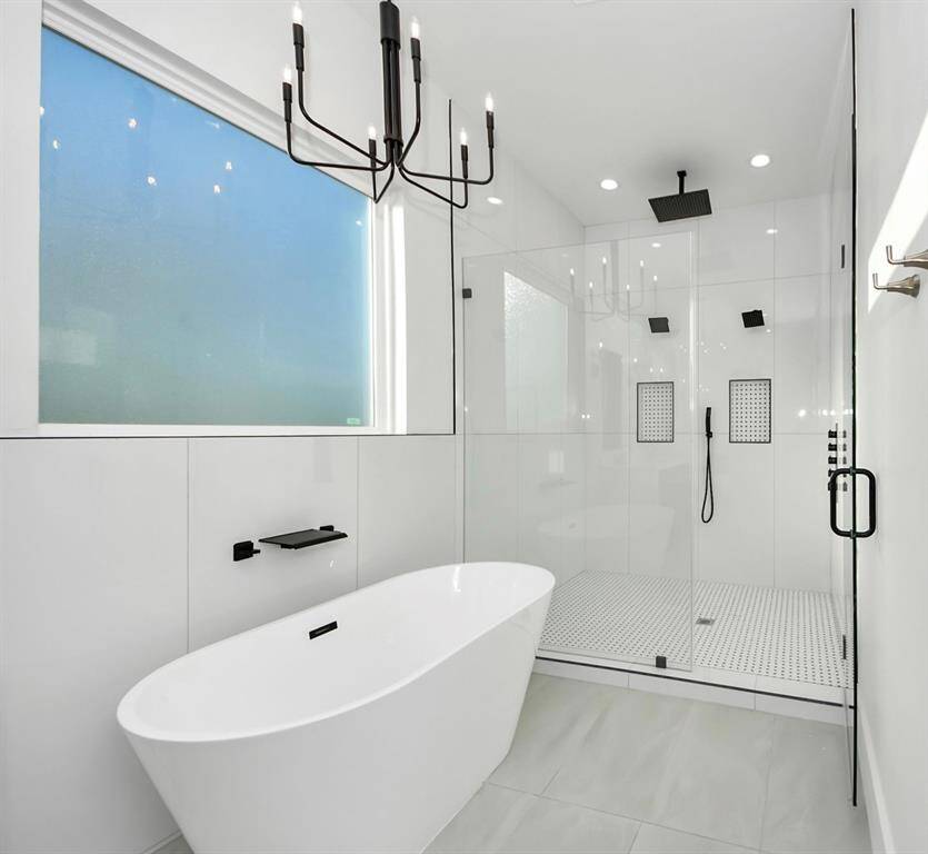 A large frosted window offers privacy while allowing natural light to fill the space, creating a serene atmosphere whether you're getting ready or soaking in the freestanding tub.