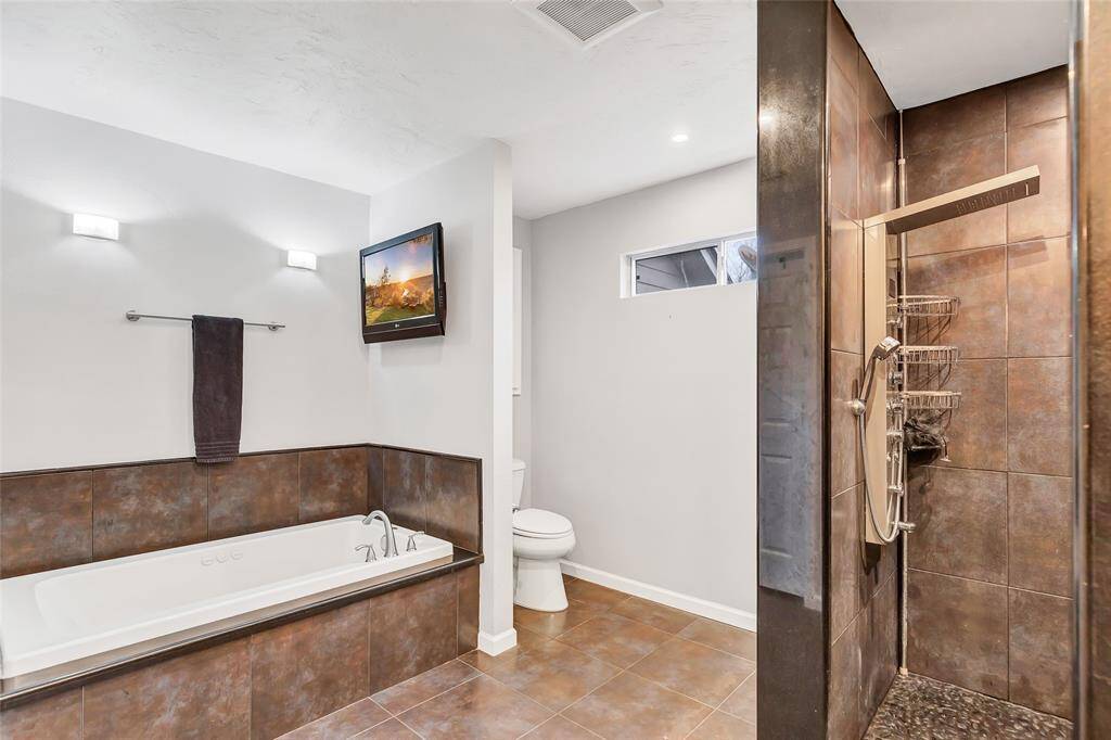 Completely updated primary bathroom with soaking tub, walk in shower, and double vanities.
