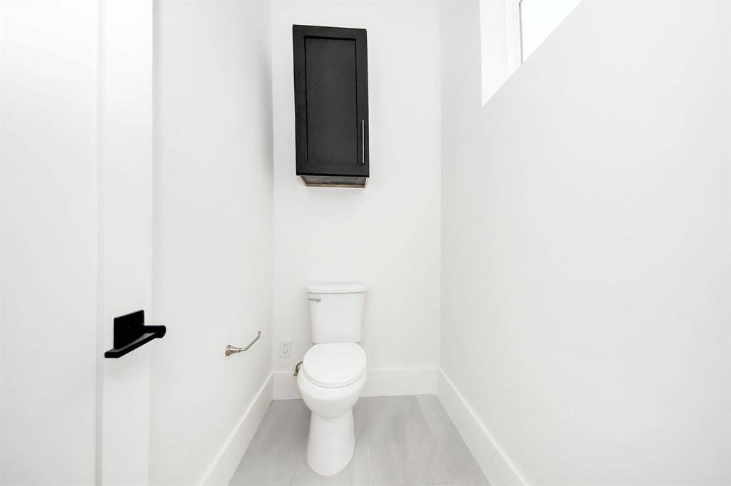 The primary suite's toilet area is spacious, offering ample room on both sides, even with the cabinetry overhead for additional storage.