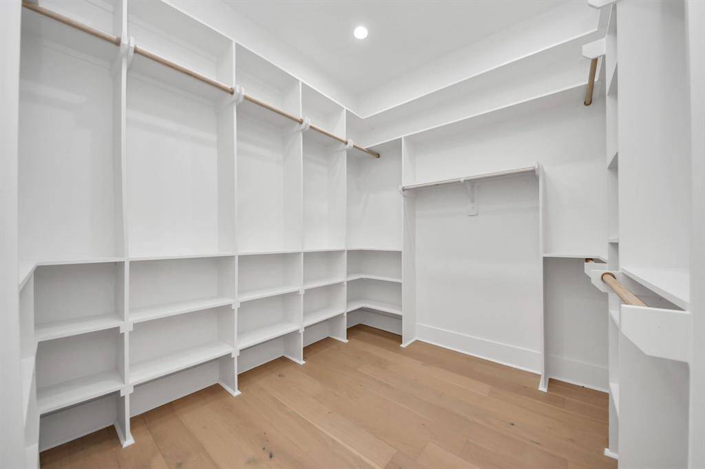 Experience luxurious craftsmanship in the expansive primary closet, featuring multiple shelves designed to accommodate everything from shoes and purses to cowboy hats and more, offering endless possibilities for organizing your wardrobe.