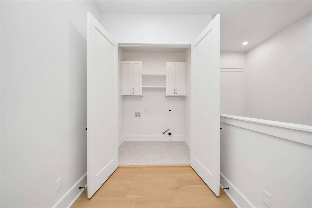 The laundry room features sleek 24x48-inch tiles, adding both style and practicality to the space, making cleanup a breeze.